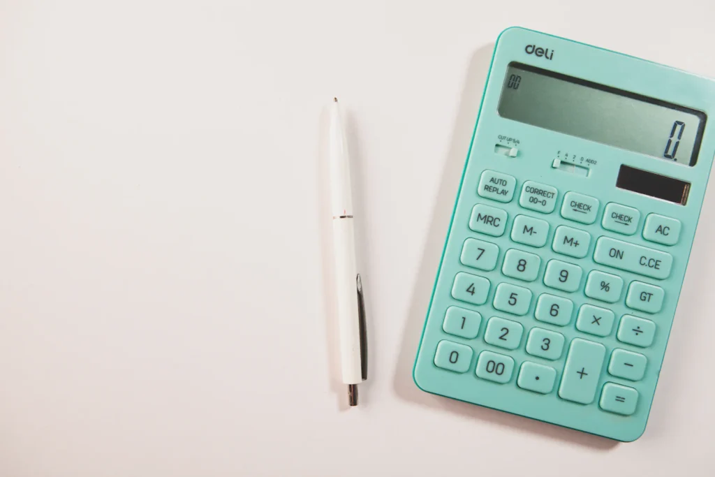 Calculadora e caneta sobre uma secretária